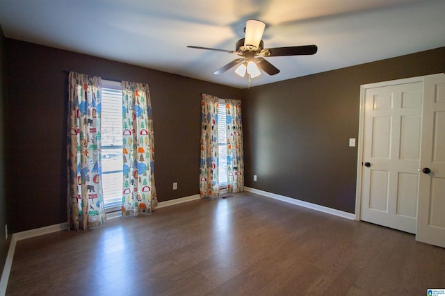 unfurnished room with ceiling fan and dark hardwood / wood-style floors