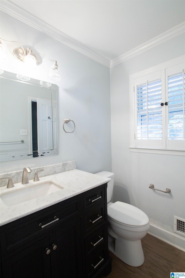 bathroom featuring hardwood / wood-style floors, vanity, toilet, and ornamental molding