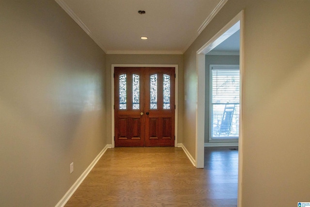 foyer entrance featuring a healthy amount of sunlight, light wood-type flooring, and ornamental molding