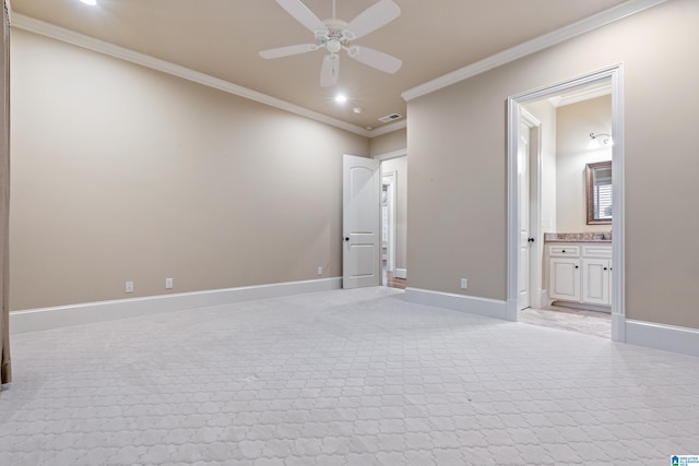 unfurnished bedroom featuring ensuite bath, ceiling fan, crown molding, and light colored carpet