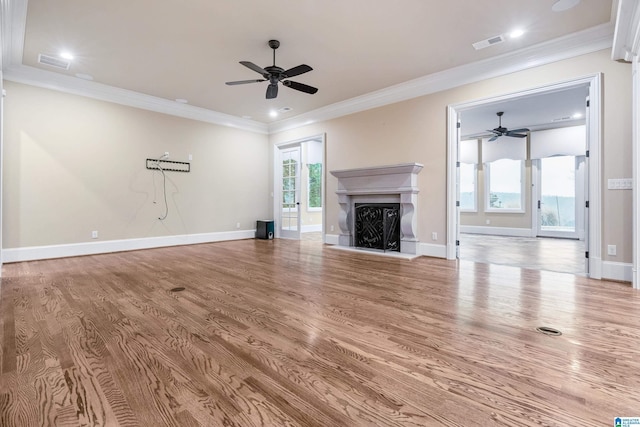 unfurnished living room featuring wood-type flooring, ceiling fan, and ornamental molding