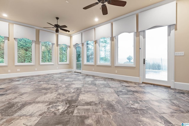 unfurnished sunroom featuring ceiling fan and a healthy amount of sunlight