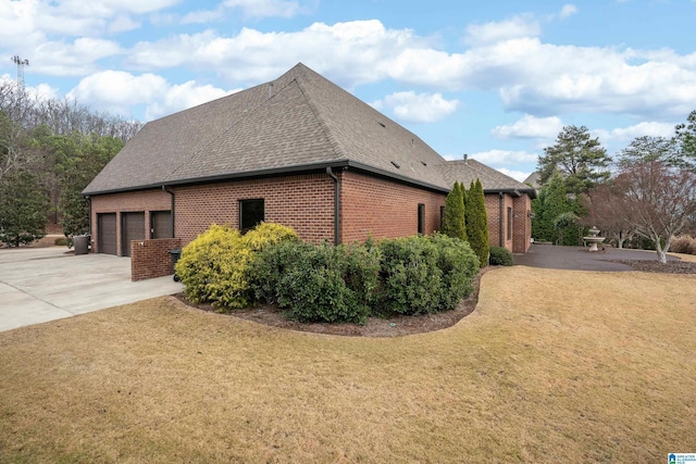 view of side of home featuring a garage and a yard