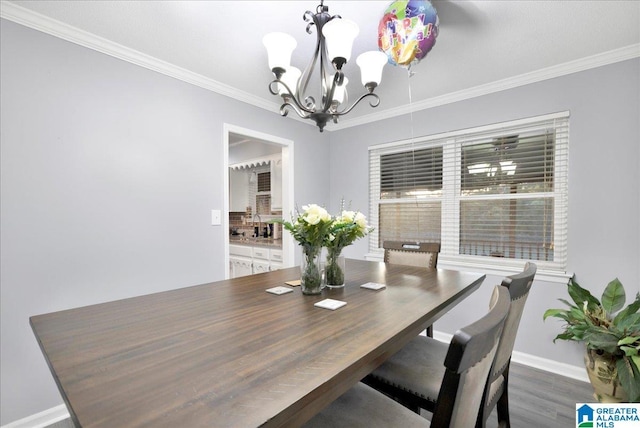 dining room with dark wood-type flooring, a chandelier, and ornamental molding