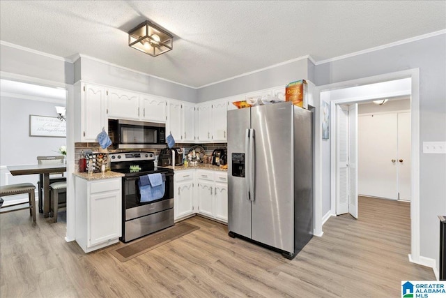 kitchen with white cabinets, appliances with stainless steel finishes, a textured ceiling, and decorative backsplash