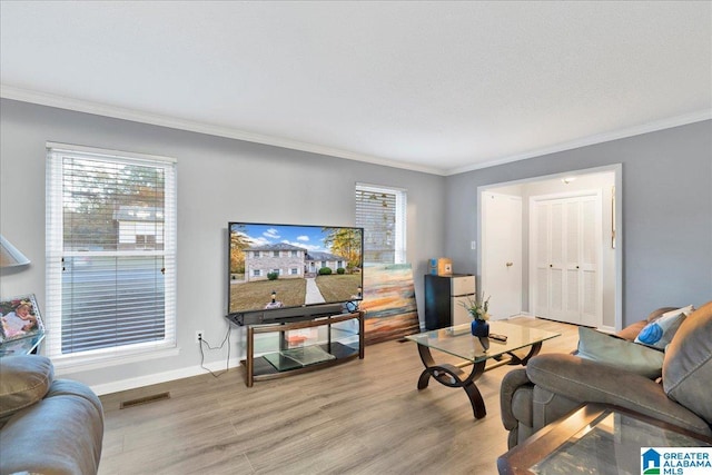 living room featuring crown molding, light hardwood / wood-style flooring, and plenty of natural light