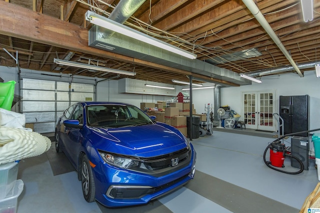 garage featuring black fridge with ice dispenser and french doors