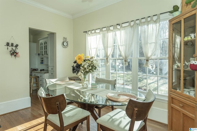 dining room with light wood-type flooring and ornamental molding