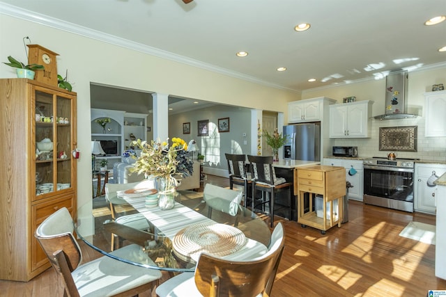 dining room featuring dark hardwood / wood-style flooring, decorative columns, ceiling fan, and ornamental molding