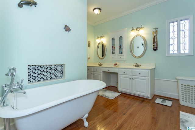 bathroom featuring crown molding, a washtub, vanity, and hardwood / wood-style floors