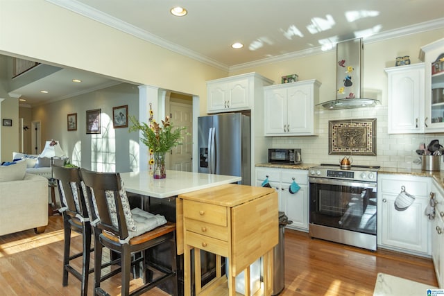 kitchen with backsplash, stainless steel appliances, white cabinetry, and wall chimney range hood