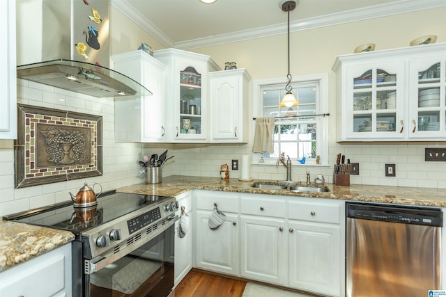 kitchen featuring wall chimney range hood, sink, light stone countertops, appliances with stainless steel finishes, and white cabinetry