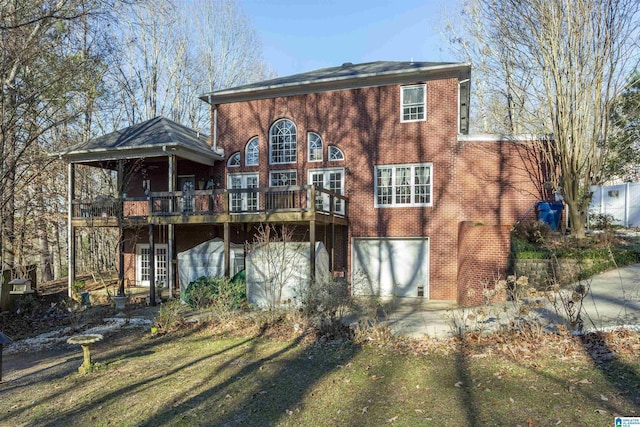 back of house featuring a lawn, a garage, and a deck