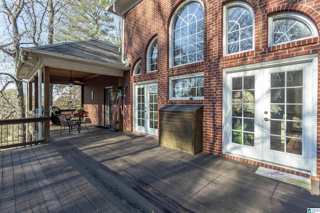 wooden deck with ceiling fan and french doors