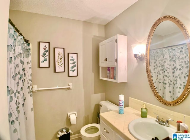 bathroom with a shower with curtain, vanity, a textured ceiling, and toilet