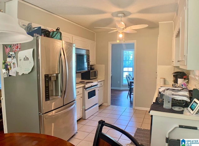 kitchen featuring appliances with stainless steel finishes, light tile patterned floors, white cabinetry, and ceiling fan