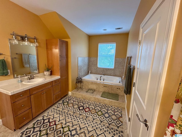 bathroom with vanity, tile patterned floors, and tiled tub