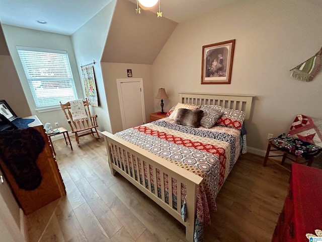 bedroom with hardwood / wood-style floors and vaulted ceiling