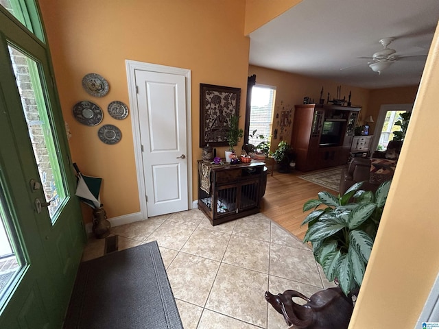 entryway with light tile patterned floors and ceiling fan