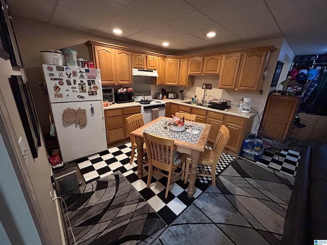 kitchen featuring a paneled ceiling, white appliances, sink, and light brown cabinetry