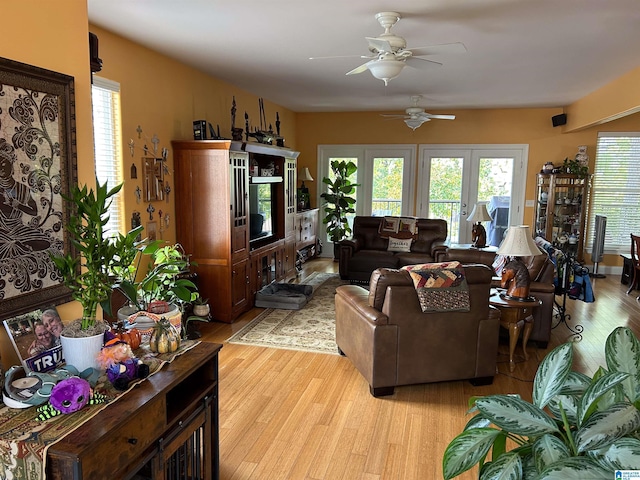 living room featuring ceiling fan, light wood-type flooring, plenty of natural light, and french doors