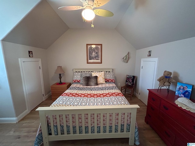 bedroom with ceiling fan, light hardwood / wood-style floors, and vaulted ceiling