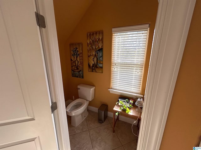 bathroom with toilet, vaulted ceiling, and tile patterned floors