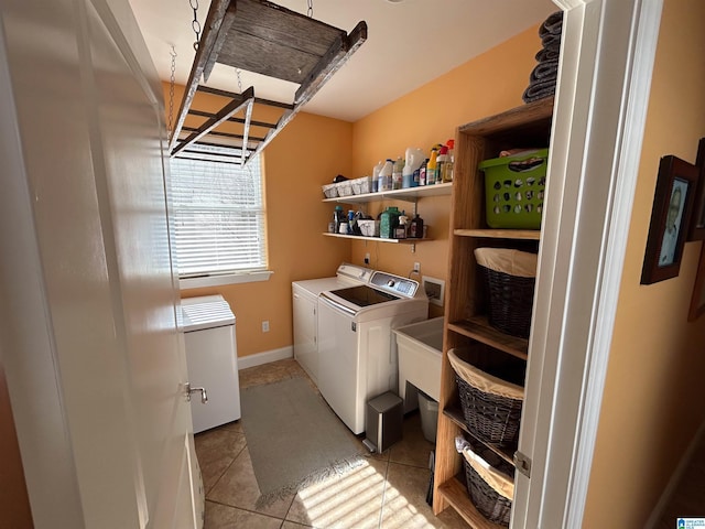 clothes washing area with separate washer and dryer and light tile patterned floors