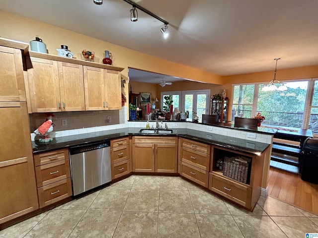 kitchen featuring sink, hanging light fixtures, stainless steel dishwasher, kitchen peninsula, and light tile patterned floors