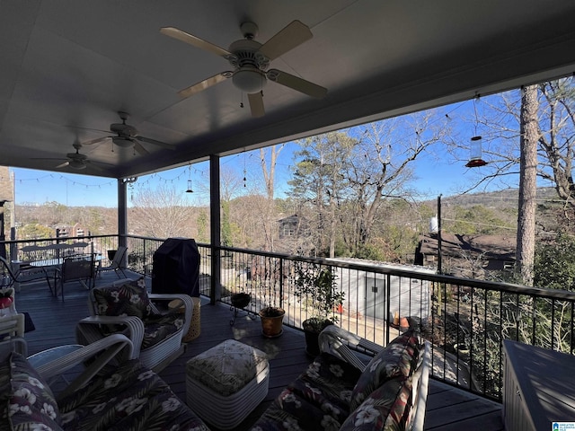 wooden terrace featuring ceiling fan and a grill