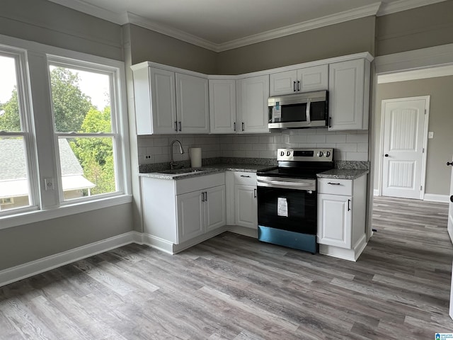 516 Main St, Warrior, AL 35180 - kitchen with white cabinets, decorative backsplash, sink, and stainless steel appliances
