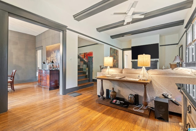 living room featuring beamed ceiling, hardwood / wood-style floors, and ceiling fan