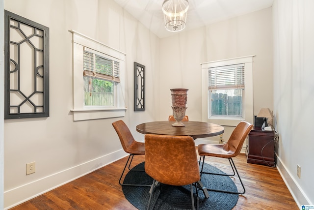 dining area with hardwood / wood-style floors and a notable chandelier