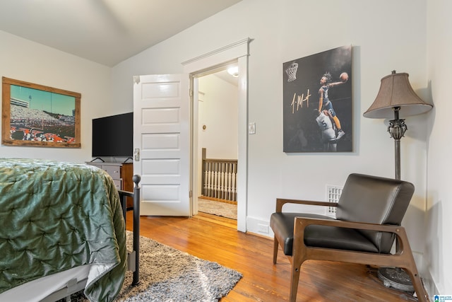 bedroom featuring wood-type flooring and vaulted ceiling