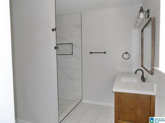 bathroom with vanity and a tile shower