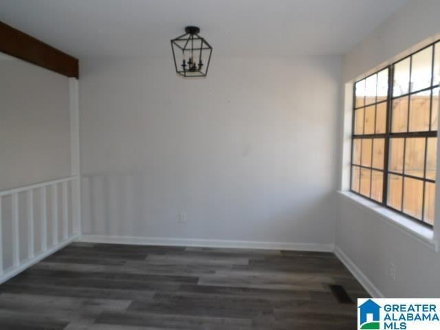 unfurnished dining area with a notable chandelier and dark hardwood / wood-style flooring