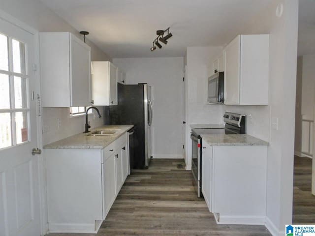 kitchen with a wealth of natural light, sink, white cabinets, and appliances with stainless steel finishes