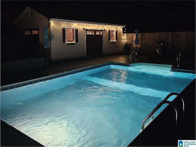 pool at twilight with a wooden deck