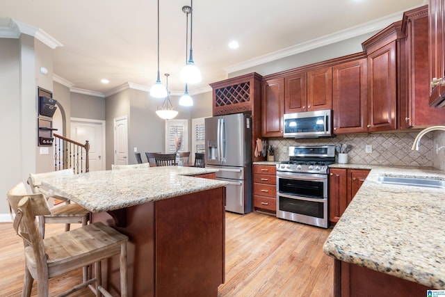 kitchen with sink, hanging light fixtures, stainless steel appliances, decorative backsplash, and ornamental molding