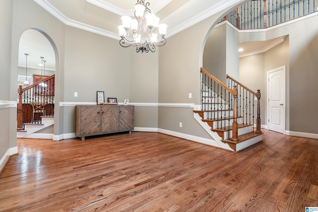 entryway featuring a tray ceiling, crown molding, hardwood / wood-style floors, and a chandelier