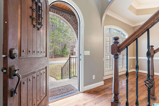 foyer entrance with light wood-type flooring and ornamental molding