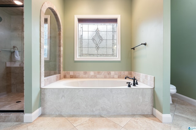 bathroom featuring tile patterned flooring, toilet, and shower with separate bathtub