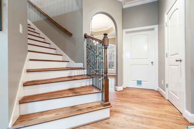 stairs with crown molding and hardwood / wood-style floors