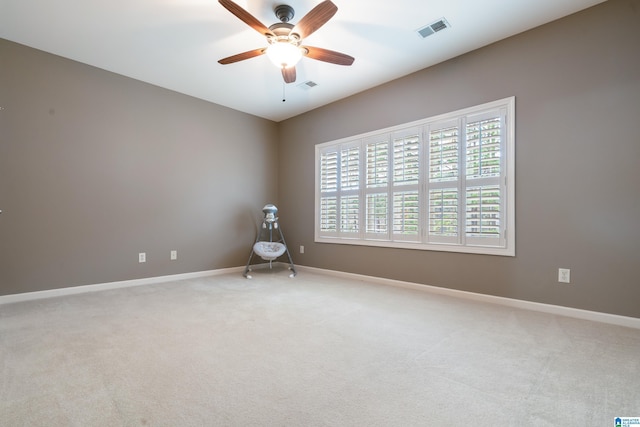 carpeted spare room with ceiling fan