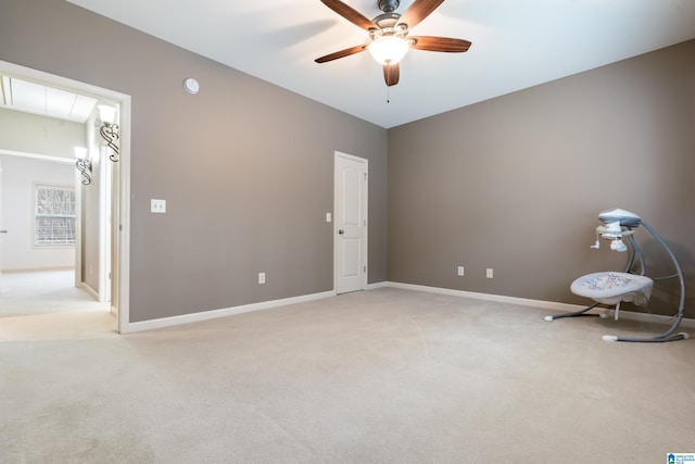 empty room featuring ceiling fan and light colored carpet