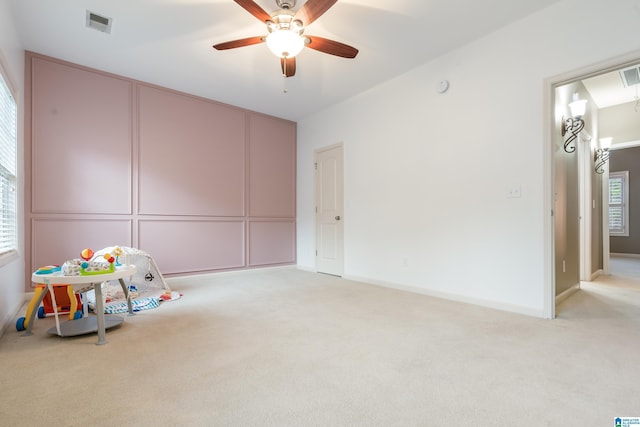 playroom featuring a healthy amount of sunlight, ceiling fan, and light carpet