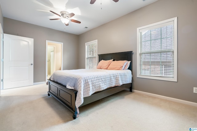 carpeted bedroom with multiple windows and ceiling fan