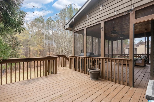 wooden terrace featuring a sunroom, ceiling fan, and a grill