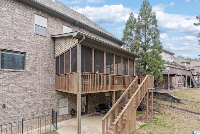 back of house featuring a sunroom, a patio area, and a wooden deck