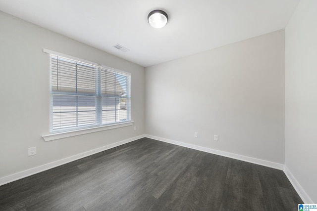 unfurnished room with dark wood-type flooring